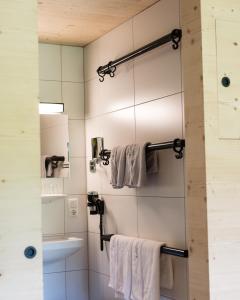 a bathroom with white towels hanging on a wall at Giatla Hof der Alfenalm - Ferienwohnungen am Berg in Innervillgraten +45 photos