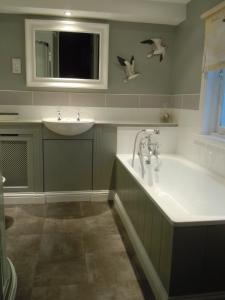 a bathroom with a sink and a bath tub at Stuart House Hotel in King's Lynn