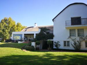a large white house with a large yard at Gemoedsrus Farm in Stellenbosch
