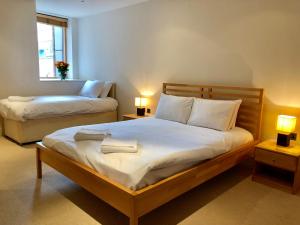 a bedroom with two beds and two lamps and a window at Luxury Apartments in Westminster in London