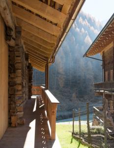 a porch of a log cabin with a view of the mountains at Giatla Hof der Alfenalm - Ferienwohnungen am Berg in Innervillgraten