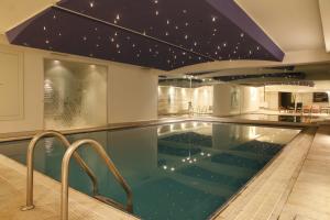 a swimming pool in a house with a ceiling with stars at Hotel Samm Bistro Spa in Ankara