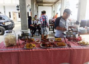 a man standing in front of a table with food at Bromo Backpacker Tosari in Pasuruan