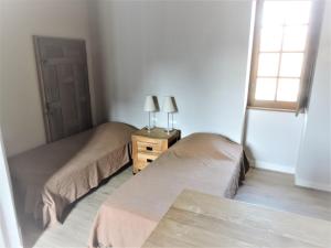 a bedroom with two beds and a table with two lamps at Escapade in Mareuil-sur-Cher