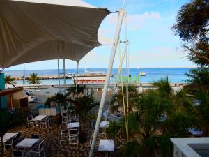 a view of the beach from a restaurant with an umbrella at Hotel Islander Bonaire in Kralendijk