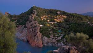 a mountain with a town on top of it at Arbatax Park Resort - Borgo Cala Moresca in Àrbatax