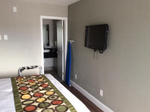 a bedroom with a bed and a tv on the wall at Ocean's 24 in Virginia Beach