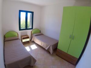 una camera con due letti e un armadietto verde di Residence Edilmare San Teodoro a San Teodoro