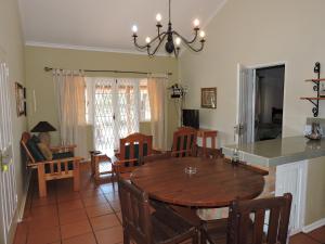 a kitchen and dining room with a table and chairs at Hluhluwe Country cottages in Hluhluwe