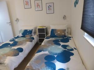2 Betten in einem Zimmer mit blauer und weißer Bettwäsche in der Unterkunft Apartmani Danica in Vodnjan
