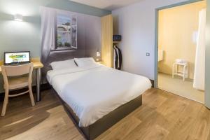 En eller flere senge i et værelse på B&B HOTEL Dijon Marsannay