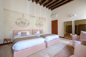 a bedroom with two beds and a couch and a chandelier at Ca' Moro Salina in Venice
