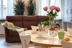 comedor con mesa y sofá en Mamo Florence - Vertical Garden Apartments, en Florencia