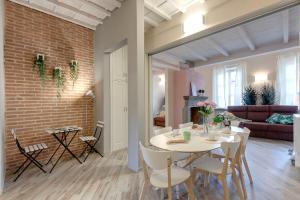 comedor y sala de estar con pared de ladrillo en Mamo Florence - Vertical Garden Apartments, en Florencia