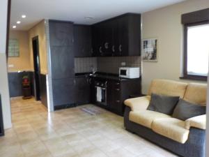 a living room with a couch and a kitchen at Las Cabraliegas in Arenas de Cabrales