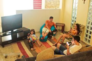 eine Gruppe von Personen, die in einem Wohnzimmer sitzen in der Unterkunft Espaço Viagi Hostel in Taubaté