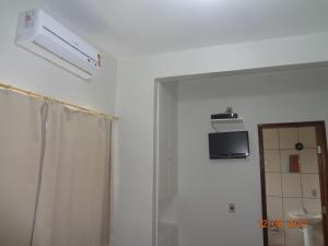 a bathroom with a shower and a microwave on the wall at Hotel Ox Inn in Uberaba