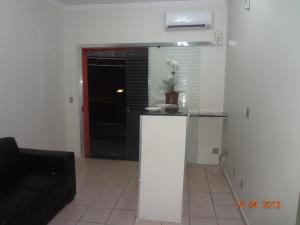 a living room with a counter and a black couch at Hotel Ox Inn in Uberaba