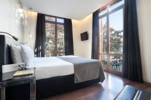 バルセロナにあるエグゼ ランブラス ボケリアのベッドと大きな窓が備わるホテルルームです。