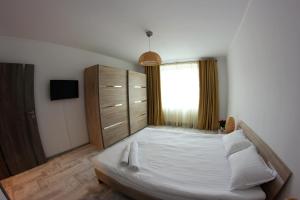 sypialnia z dużym białym łóżkiem i komodą w obiekcie Apartament Centru Istoric Radu w Sybinie