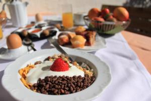 ein Tisch, auf dem ein Dessert mit einer Erdbeere thront in der Unterkunft Hotel Haselried in Dorf Tirol + 47 Fotos