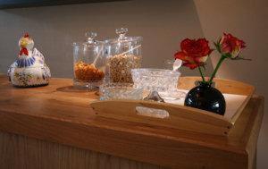 a wooden counter with bowls of food and a vase with a flower at Hotel Gevers in Scheveningen