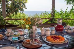 una tavola con cibo sopra con l'oceano sullo sfondo di Agriturismo Natta Di Monte Tabor a Celle Ligure