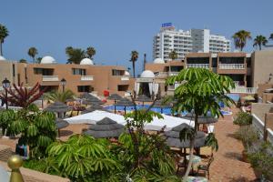 a resort with a bunch of tables and umbrellas at Parque de las Américas in Playa de las Americas