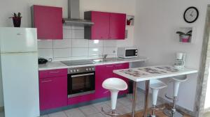 a kitchen with purple cabinets and a white refrigerator at Apartment Dunja in Senj