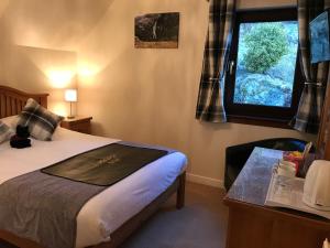 a hotel room with a bed and a window at Ben Nevis Guest House in Fort William