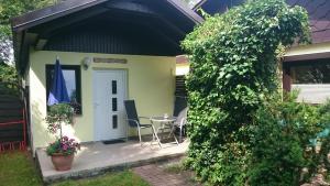 a small house with a white door and a table at Bungalow "Achtern" in Zingst