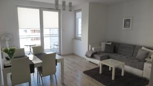 グダニスクにあるBTS Apartaments - Apartamenty Blisko Morzaのリビングルーム(ソファ、テーブル付)