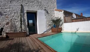 a house with a swimming pool on a wooden deck at La Terrasse de La Tremblade in La Tremblade