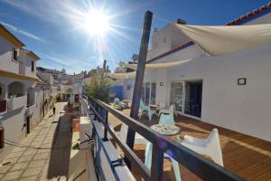 a balcony with tables and chairs on a building at Son of a Beach Hostel in Albufeira