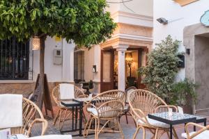 un patio con mesas y sillas frente a un edificio en The Town House - Adults Only, en Marbella