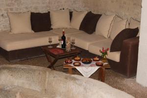 salon z kanapą i stołem z kieliszkami do wina w obiekcie Manoir de la Pataudière B&B w mieście Villers-Canivet