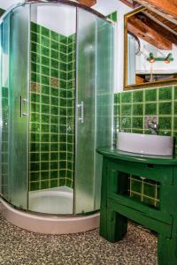 W łazience znajduje się wyłożona zielonymi kafelkami prysznic i umywalka. w obiekcie Penzión u Maroša w Kieżmarku