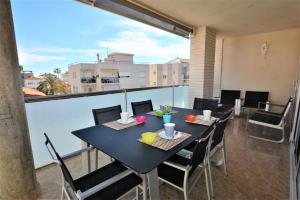 a dining room with a table and chairs on a balcony at Villaservice - Rovior Atico in Calafell