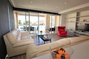 a living room with a white couch and a red chair at Villaservice - Rovior Atico in Calafell