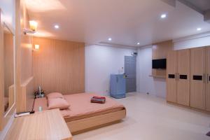 - une petite chambre avec un lit et un réfrigérateur bleu dans l'établissement TN Thanyawit, à Nakhon Ratchasima