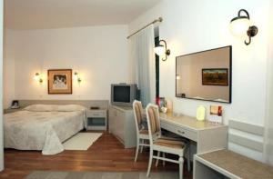 Schlafzimmer mit einem Bett und einem Schreibtisch mit einem Computer in der Unterkunft Hotel Senator-Ház Eger in Eger