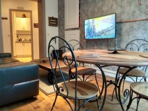 a dining room with a table and chairs and a television at Chic apart in Paris in Saint-Denis