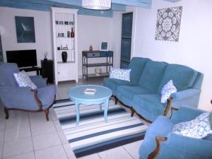 - un salon avec des canapés bleus et une table dans l'établissement Le Gîte de la Porte Bleue, à Guillac