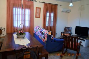 a living room with a blue couch and a wooden table at Posada La Reja in Malpica