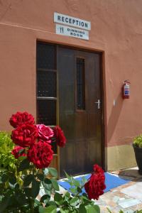 una puerta a un edificio con rosas rojas delante de él en Seelo Guest Accommodation en Letlhakawe