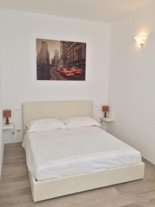 スペッキアにあるLa casa di Andreaの壁に絵が描かれたベッドルームの白いベッド1台