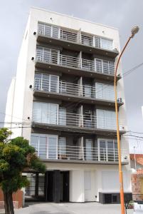 un edificio de apartamentos con balcones y luz de la calle en Departamentos con cochera Peru 157 en Bahía Blanca