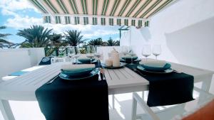 a white dining table with black table runners and candles at Barbican in Playa Honda