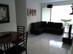 a living room with a black couch and a table at CH1 Bonito apartamento amoblado en condominio RNT 1O8239 in Valledupar