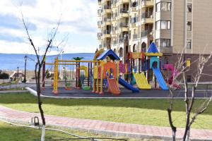 a playground in a park in front of a building at Aden Apartments in Tbilisi City